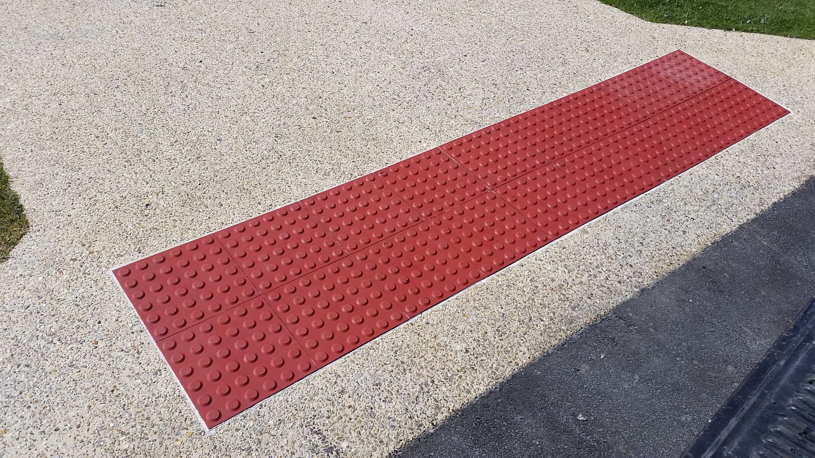 Red tactile indicators installed in a pathway